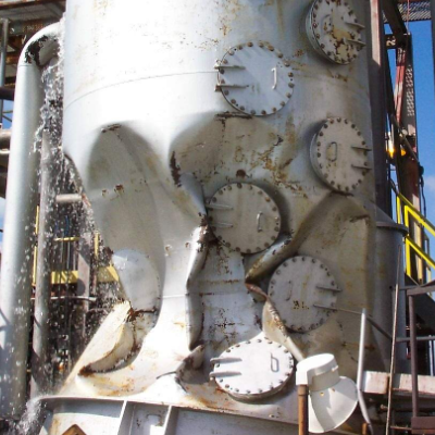 Vacuum failure of a barometric condenser (vacuum vessel) after the internal support rings failed. The volume of the vessel decreases.